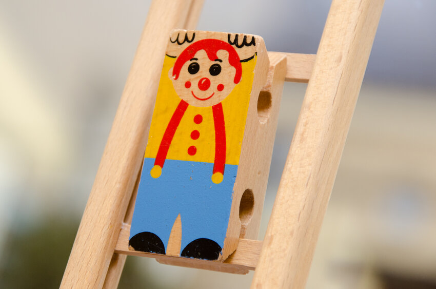 Holzfigur eines Clowns auf einer Leiter