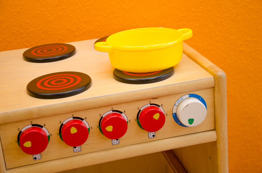 Spielzeugherd mit gelbem Topf