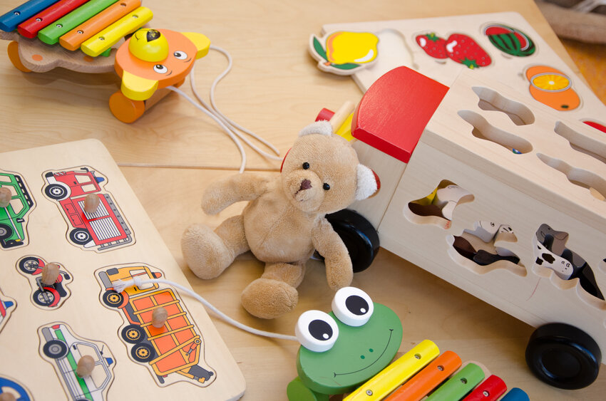 Plüschbär und Holzspielzeuge auf einem Tisch